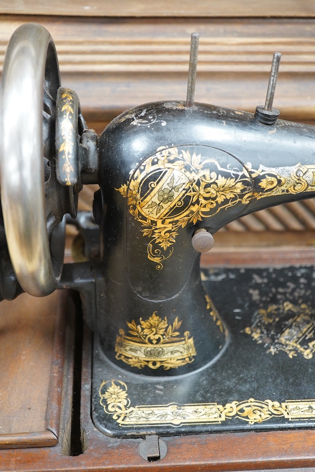 An early 20th century cased Singer sewing machine, 46cm wide at base. Condition - poor